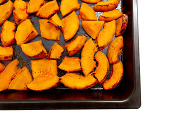 Pieces of pumpkin baked on a baking sheet