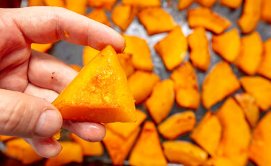 Oven baked pumpkin in a man's hand.