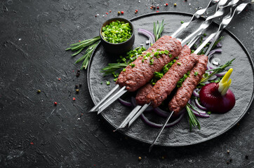 Traditional kebab with rosemary and onions. Grilled veal skewers. Top view. Free space for your text.