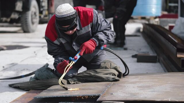 Factory worker is welding in protective helmets and glasses