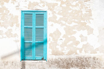 Wooden Turquoise window shutters on a grunge wall