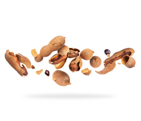 Crushed tamarind fruits in the air on white background