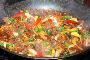 A close-up of Bulgogi, a Korean beef stir-fry, in a frying pan.