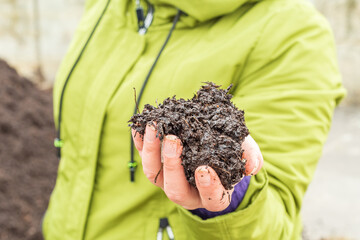 Woman checks the quality of arable soil