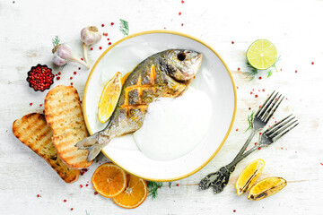 Baked Dorado fish in a creamy sauce. Top view. Free space for text.