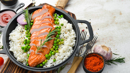 Baked chicken fillet with rice and vegetables on a black stone plate. Diet food. Top view. Free space for your text.