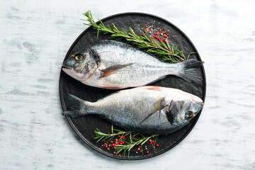 Raw dorado fish with spices. On a white wooden background. Top view.