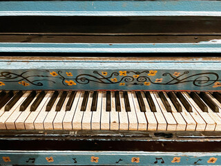 Artistic and Colorful Painted Floral Piano.  The piano is an antique and looks weathered and old.