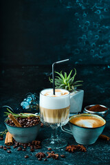 Coffee set: coffee beans, latte coffee and cappuccino. On a black background. Top view.