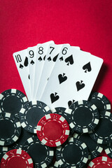 Obraz premium Winning poker combination is a Straight Flush. Chips and cards on the red table in the poker club. Luck or Fortune