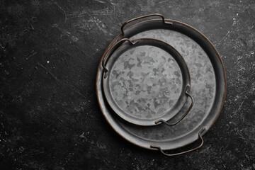 Old retro metal tray on a black stone background. Top view. Free copy space.