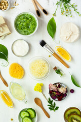 Concept of natural organic ingredients for homemade face and body care products. Essential oils, fruits, vegetables, flowers for skin purifying and moisturizing. White background, flat lay top view