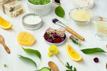 Concept of natural organic ingredients for homemade face and body care products. Essential oils, fruits, vegetables, flowers for skin purifying and moisturizing. White background, flat lay
