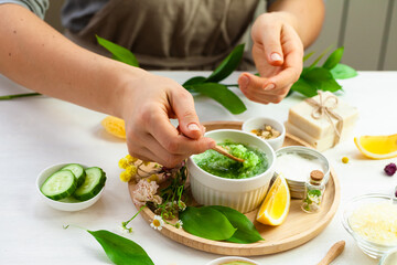 Girl in process of preparation of homemade refreshing cucumber mask. Self care, home face and body treatment durine lockdown. Concept of natural organic ingredients and essential oil in cosmetics