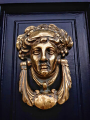 Female head door knocker on Georgian black door.