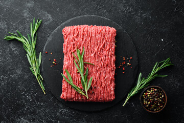 Raw minced meat on a black surface. Top view. Free space for your text.