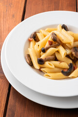 Piatto di deliziose penne condite con funghi e carote, Cucina Vegetariana Italiana 