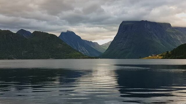 Dramatic clouds in a Norwegian fjord with mountain landscape on a grey day