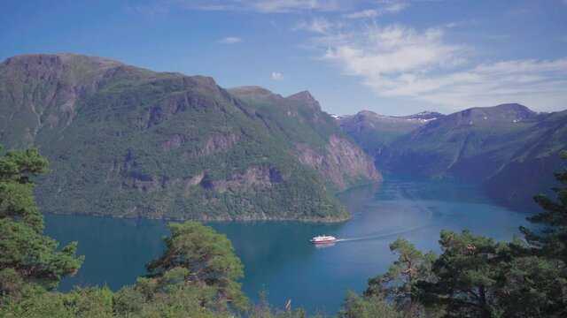 Hurtigruten ferry sailing in geiranger fjord on a sunny day, scenic Norwegian mountain landscape