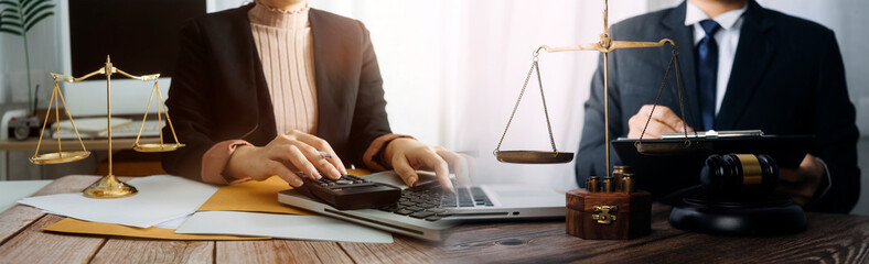 Justice and law concept.Male judge in a courtroom with the gavel, working with, computer and docking keyboard, eyeglasses, on table in morning light