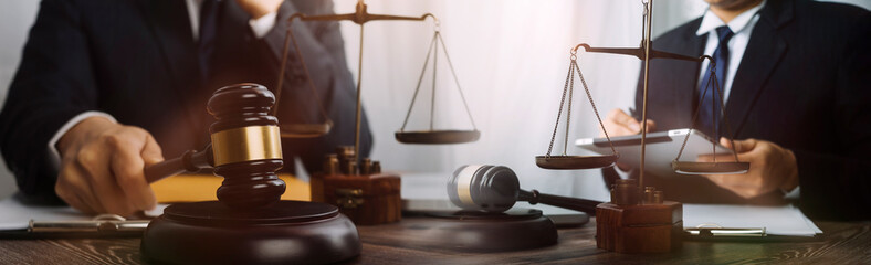 Justice and law concept.Male judge in a courtroom with the gavel, working with, computer and...