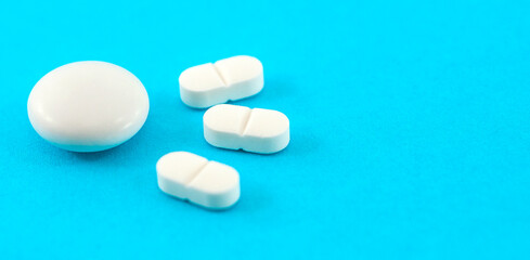 white pills  with copy space on a blue background. Pharmacy