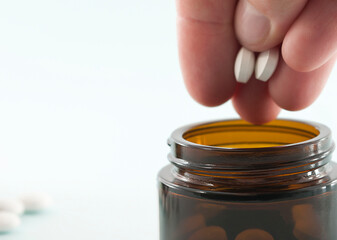 pills are placed in a jar of dark glass