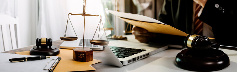 Business and lawyers discussing contract papers with brass scale on desk in office. Law, legal services, advice, justice and law concept picture with film grain effect