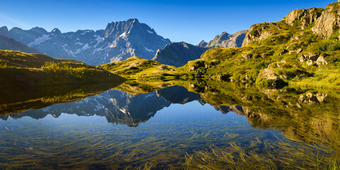 Lauzon Lake in the Ecrins National Park in summer with a view on the Sirac mountain peak. The lake...
