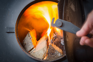 Furnace of a stove with burning wood. Warmth, home comfort of a country house.