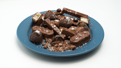 Composition of bars and pieces of different milk and dark chocolate, cocoa grater on a white background, top view