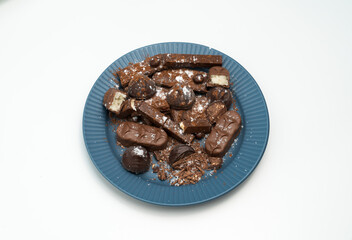 Composition of bars and pieces of different milk and dark chocolate, cocoa grater on a white background, top view