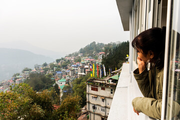 Fototapeta na wymiar A young female tourist enjoying the view of beautiful Gangtok the capital city of Sikkim.