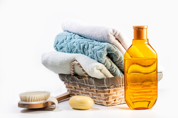 Bathroom Set on white background - Shampoo, brush and towels in a wicker basket
