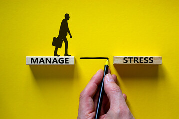 Manage stress symbol. Wooden blocks with words 'manage stress'. Beautiful yellow background. Businessman hand, businessman icon. Psychological, business and manage stress concept. Copy space. - obrazy, fototapety, plakaty