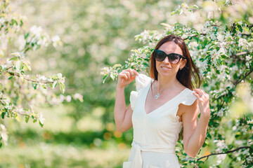 Spring mood, beautiful woman smell flowering tree, enjoying nature, white floral garden.