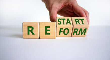 Restart and reform symbol. Businessman turns cubes and changes the word 'restart' to 'reform'....