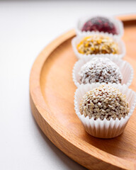 Four healthy organic energy balls in the wood desk on white background