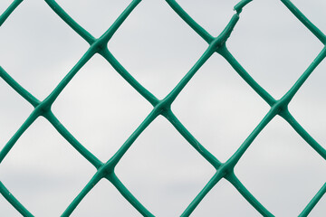 mesh green plastic fence against the sky