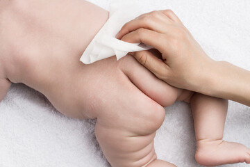 Hygiene of newborns. Mom washes the baby with a wet napkin the baby's body.