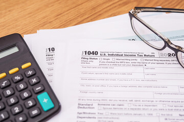 tax forms 1040 with calculator and glasses