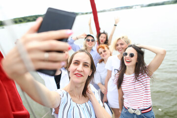 Portrait of cheerful company taking selfie on smartphone