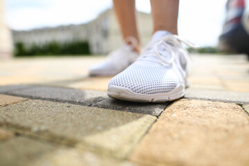 Close-up of person wearing shiny white sneakers