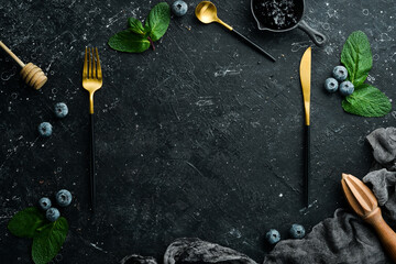 Culinary black background with utensils and spices. Top view. Rustic style.