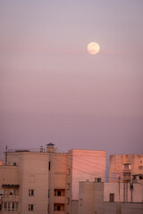 full moon over the houses of the city