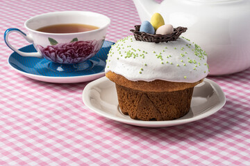 decorated Easter cake on a table with cup of tea