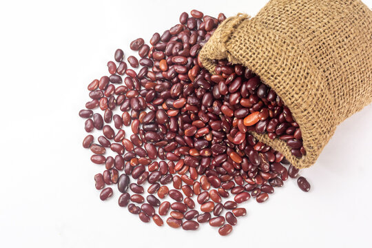 Fresh organic red kidney beans or rajma in a sackcloth bag on white background.