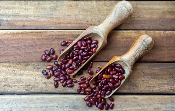 Fresh organic red kidney beans or rajma in wooden scoop on wood background.
