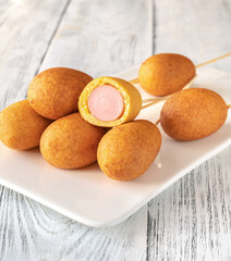 Corn dogs on white serving plate