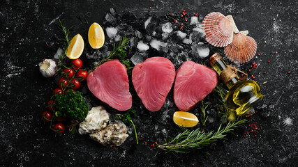 Fototapeta na wymiar Raw tuna steak with spices on ice. On a dark background. Top view.